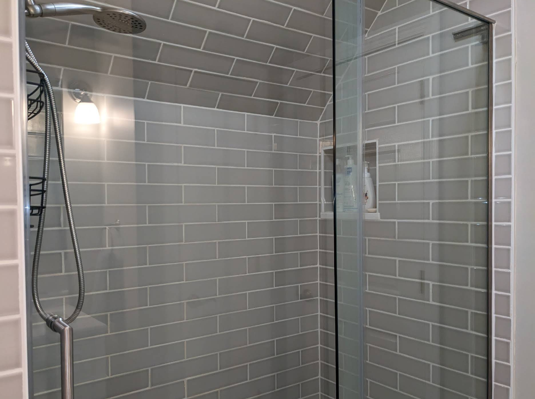 Sparkling walk-in shower with gray subway tile and streak-free glass door in Rochelle IL