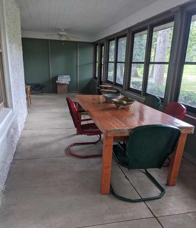 Freshly cleaned screened-in porch with wood table and vintage chairs in Rochelle IL