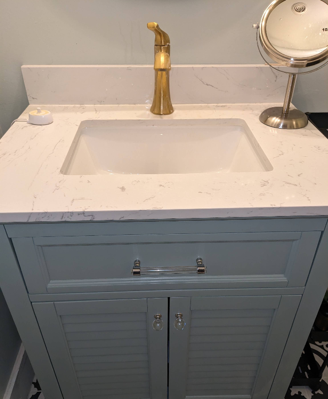 Polished bathroom vanity with white quartz counter and brass fixtures after deep cleaning in Rochelle IL
