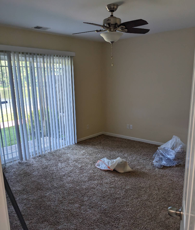 Bright bedroom with sliding glass door and vacuumed carpet during move-out cleaning in Rochelle IL